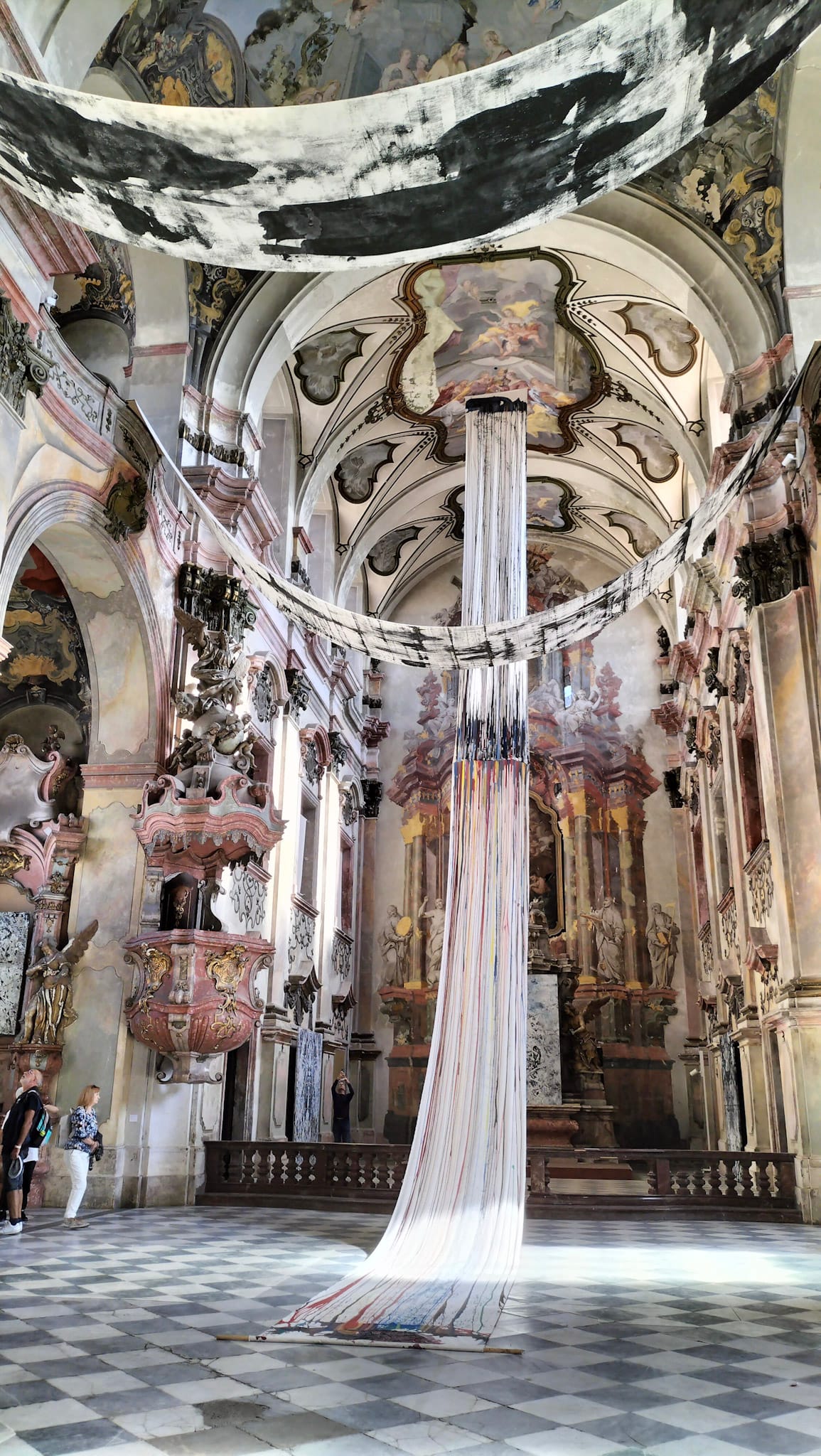 Im Schiff einer Kirche hängt eine Stoffbahn von der Decke bis zum Boden herunter.